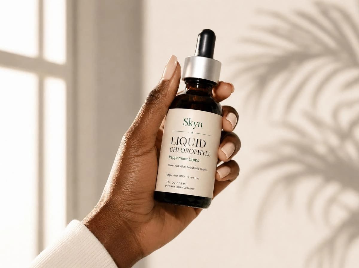 Dark-skinned hand holding Skyn Liquid Chlorophyll bottle in warm natural light